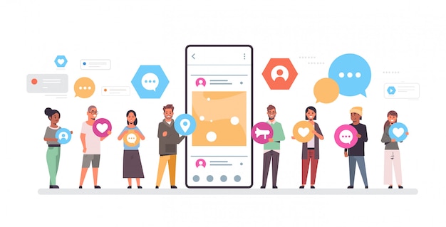 People group holding different types of communication icons mix race men women standing together near smrtphone screen online mobile app social network concept full length horizontal