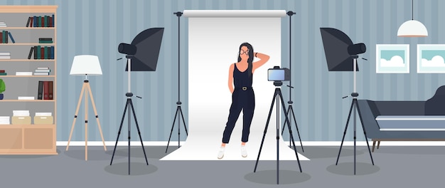 Photo studio girl posing to the camera. white canvas background on tripods.