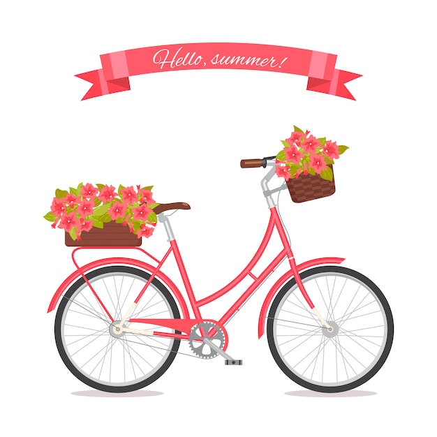 Pink retro bicycle with bouquet in floral basket and box on trunk.
