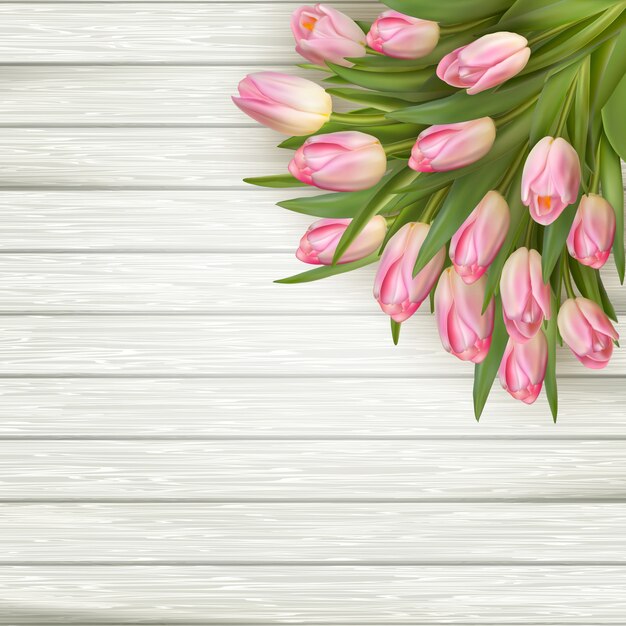 Pink tulips over white wood table.