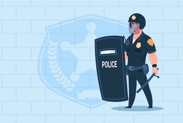 policeman hold shield wearing helmet uniform cop guard over brick background