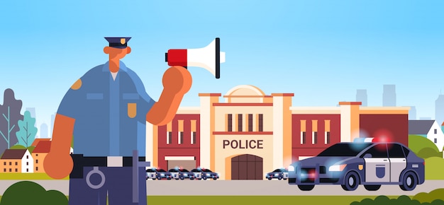 Policeman in uniform using loudspeaker making announcement security authority justice law service concept modern police station department building exterior portrait