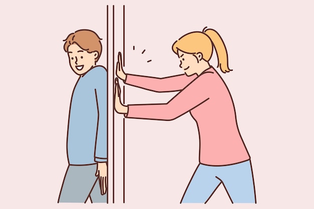 Positive man hides behind door preventing girlfriend from passing or arranging prank