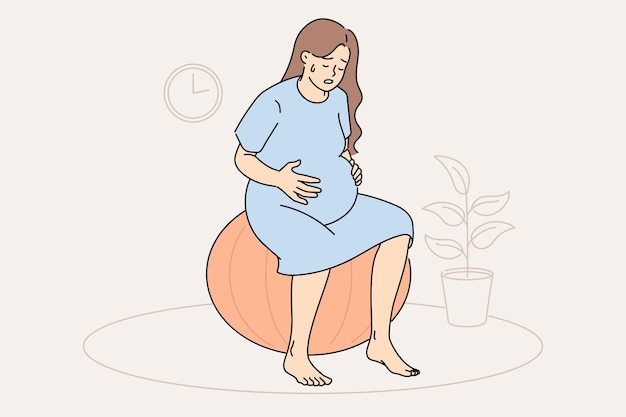 pregnant woman feels contractions and labor is approaching sits on fitness ball