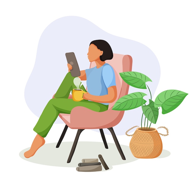 Pretty girl sitting in comfy armchair with a tablet and cup of coffee.