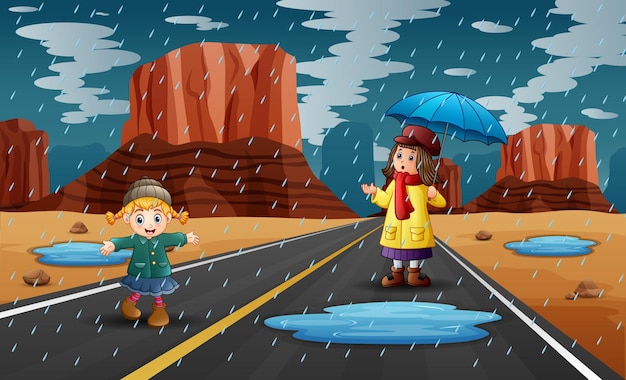 Stagione delle piogge con due ragazze che giocano sotto la pioggia