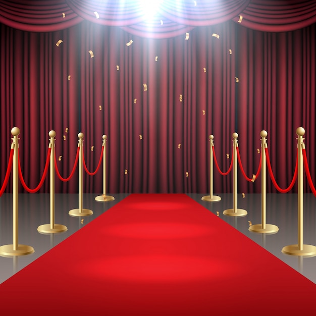 Red carpet and curtain and barrier rope in glow of spotlights