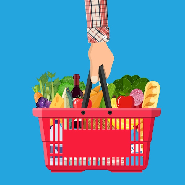 Red plastic shopping basket full of groceries products in hand