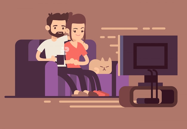 Relaxed happy young couple watching tv at home in living room