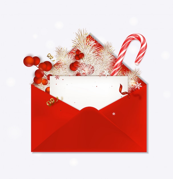 Rode envelop geopend met christmas wenskaart. suikerriet, dennentakken, rode bessen, vakantie decoratie