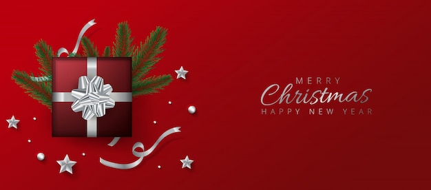 Rode koptekst of bannerontwerp versierd met geschenkdoos, kerstballen en dennenbladeren voor prettige kerstdagen en gelukkig nieuwjaar.