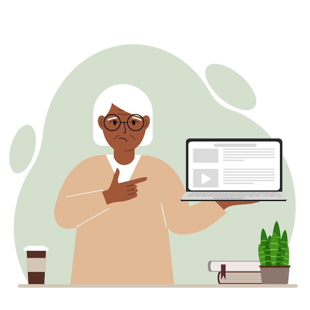 Sad grandmother holding a laptop computer with one hand and pointing at it with the other. Laptop computer technology concept.