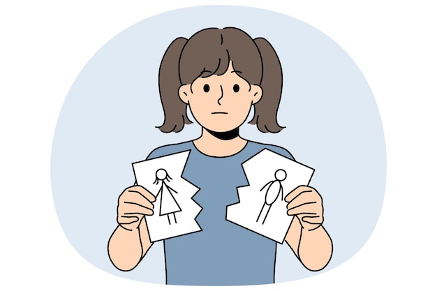 sad little girl is nervous about parents divorce and is holding torn drawing of mom and dad