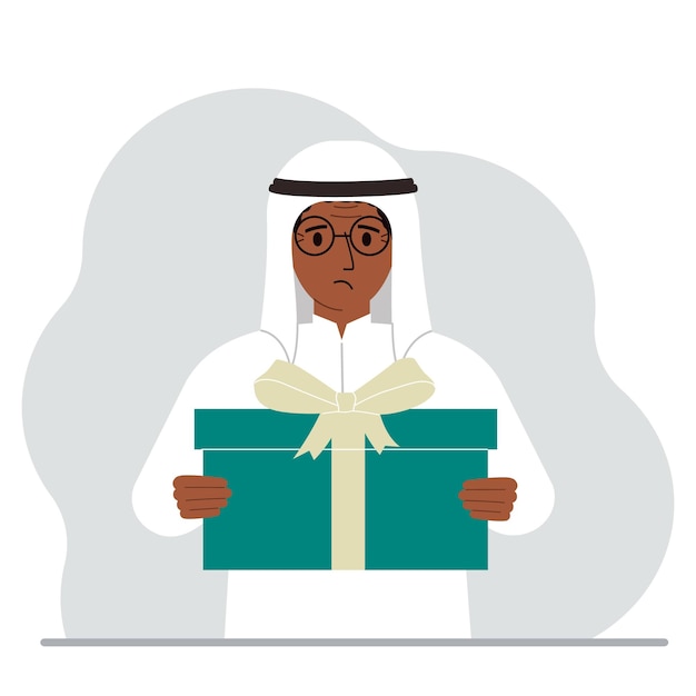 슬픈 이슬람 남자는 손에 활이 든 큰 선물 상자를 들고 있습니다.