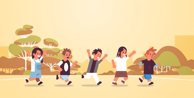 School children group running together elementary age schoolchildren group having fun outdoor male female pupils landscape background flat full length horizontal