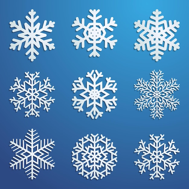 Набор белых снежинок различных форм с тенями на синем фоне