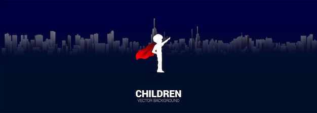 Silhouette of boy in superhero suit point to sky in city. Concept of education start and future of children.