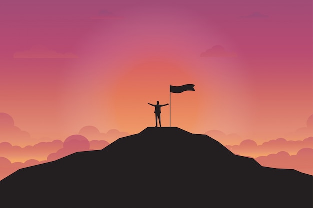 Silhouette of businessman and flag on top mountain