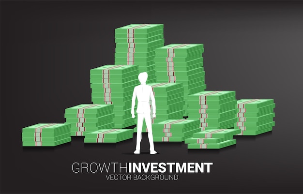 Silhouette of businessman standing on top and stack of banknote. concept of success investment and growth in business