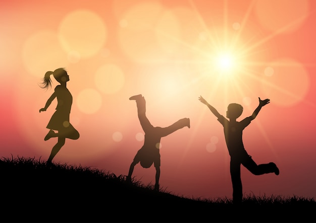 Silhouettes of children playing in sunset landscape