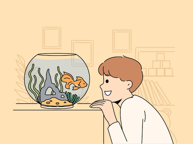 Smiling child look at goldfish in tank