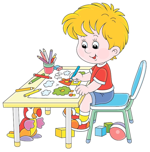 Smiling little boy sitting at his table and drawing with color pencils a funny picture