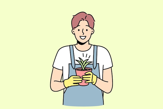 Smiling man gardener holding plant