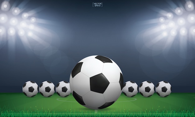 Soccer football ball and green grass of soccer field stadium background