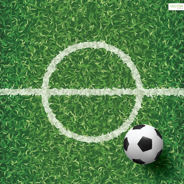 Vector soccer football ball on green grass of soccer field with center line area.