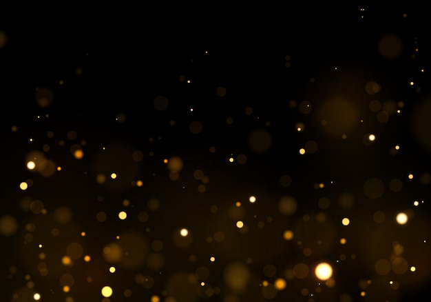 Sparkling magical gold yellow dust particles. Abstract black background with bokeh effect.