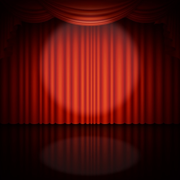 Spotlight on stage and red curtain.