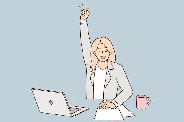 successful woman manager celebrates victory and raises hand up sitting at table with laptop