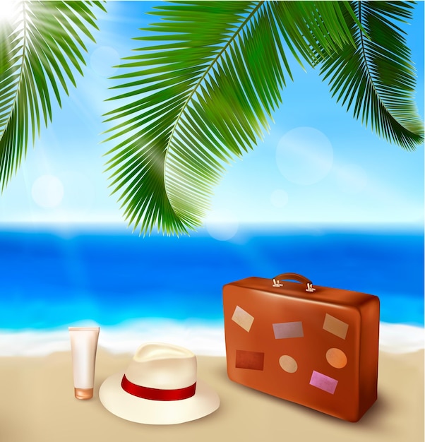 A suitcase and a hat are on the beach under a palm tree.