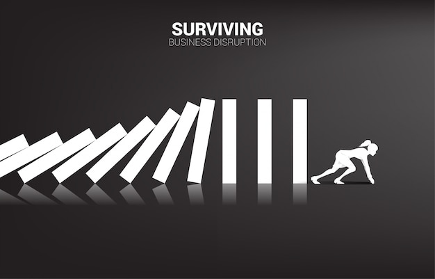 surviving business disruption. silhouette of businesswoman ready to run away from domino collapse. concept of business industry disrupt