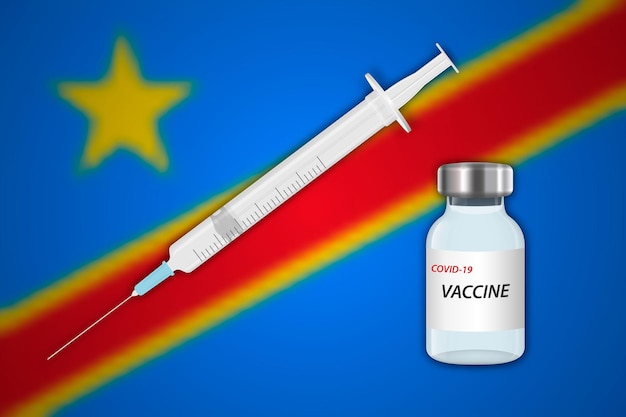コンゴ民主共和国の旗とぼかしの背景に注射器とワクチンのバイアル