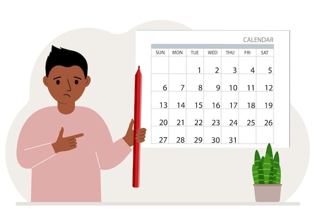 Мальчик держит красный карандаш и стоит возле большого календаря