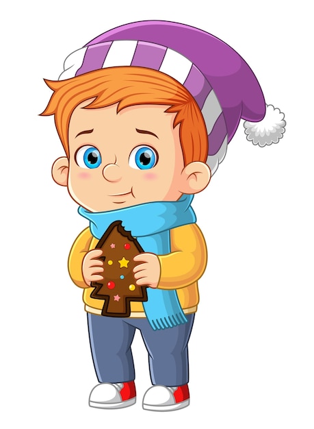 귀여운 소년이 초콜릿 진저브레드맨을 먹고 크리스마스를 축하하고 있다