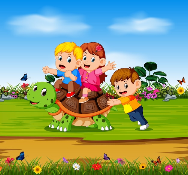 three children are playing on the big turtle in the forest