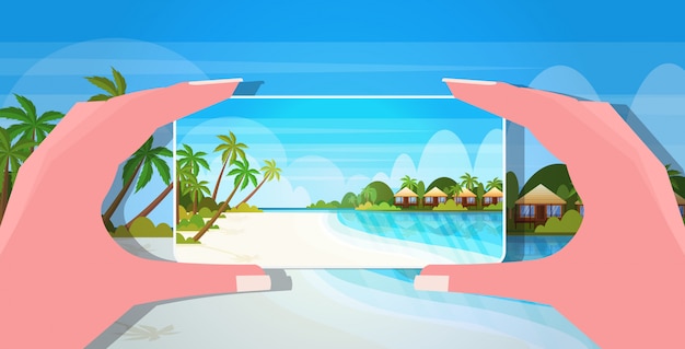 スマートフォンのカメラの女性の手を使用して写真やビデオを携帯電話ブログ撮影vlogコンセプト海のビーチ夏休み海の背景の水平方向を撮影旅行ブロガー