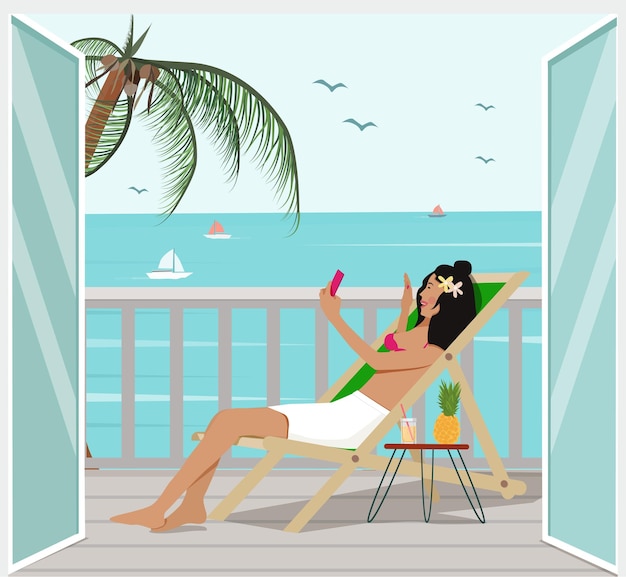 A tropical resort on vacation A woman lies in a chair by the sea and makes a video call