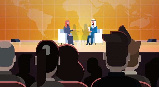 Two Arab Business Men Or Politicians On Conference Or Debate Meeting Interview Talking Sit Over World Map In Front Of Big Audience