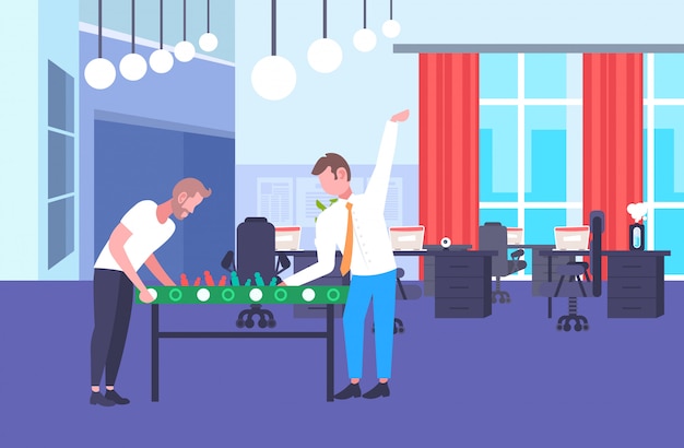 two businessmen coworkers playing table football colleagues having fun together during break business people relaxing office co-working center interior horizontal full length