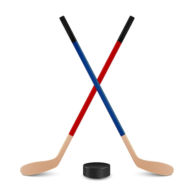 Two crossed hockey sticks - red and blue - and puck. Isolated on white background.  