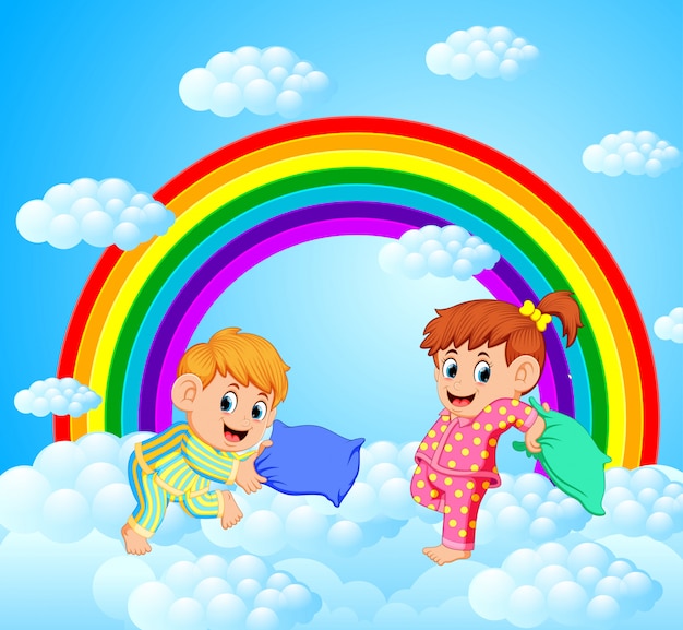 Due bambini felici sta combattendo un cuscino con uno scenario arcobaleno