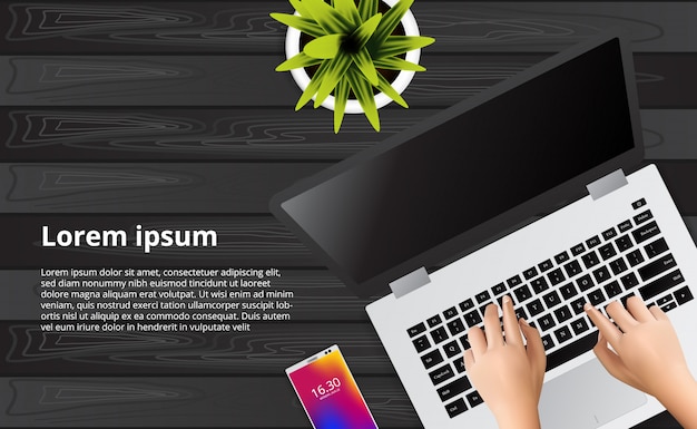 Typen laptop op het houten bureau met illustratie van telefoon, plant.