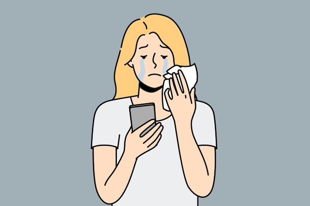 Несчастная женщина смотрит на экран мобильного телефона и плачет