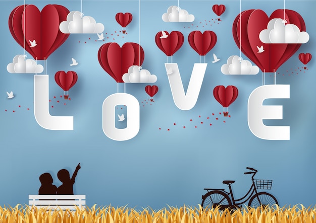 Vector valentine's day concept boy and girl sitting on a table with a bike. balloon floating in the sky with the letters love