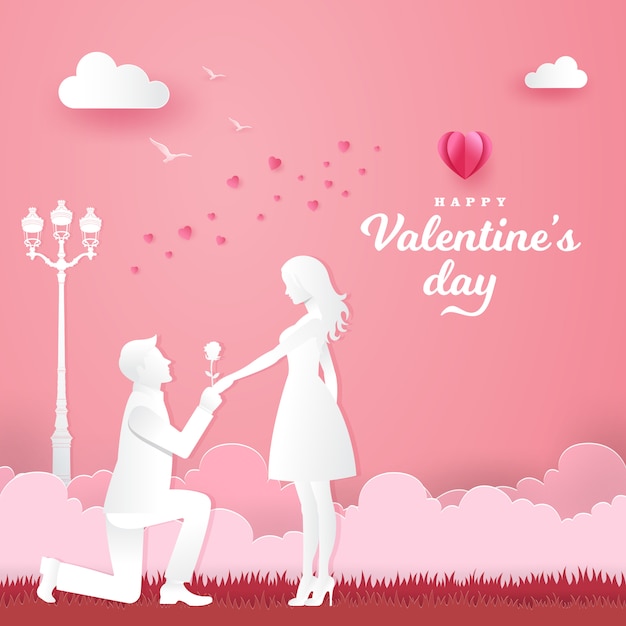 Valentine's day greeting card. young man kneeling to his girlfriend and giving a rose on the park with heart and pink