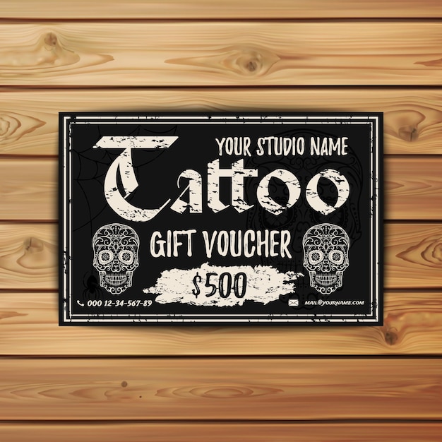 Vintage Tattoo gift voucher. Template for your tattoo studio. Black grunge gift card with sugar rskulls on wooden background. Vector illustration.