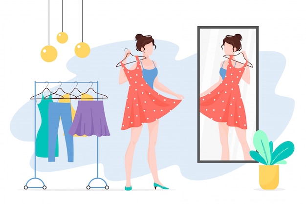 Женщина выбирает одежду и смотрит в зеркало